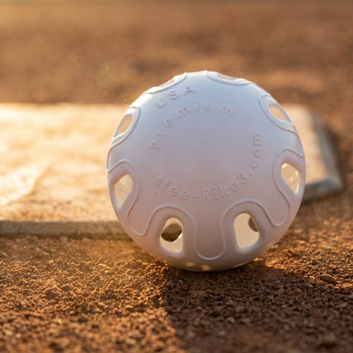 White Stee-Rike 3 training ball on baseball field dirt — standard ball in multipack